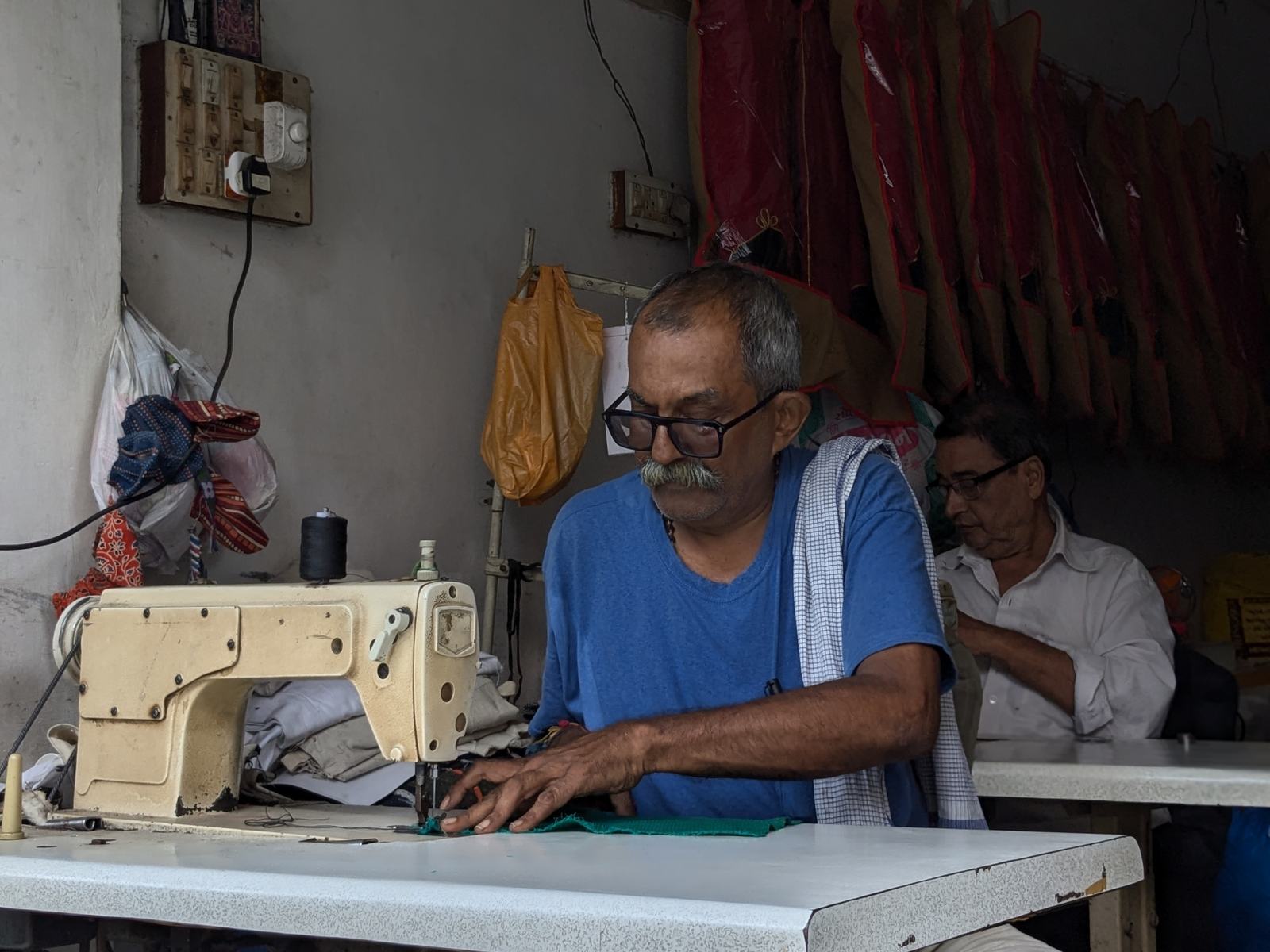 a tailor guides fabric through a sewing machine