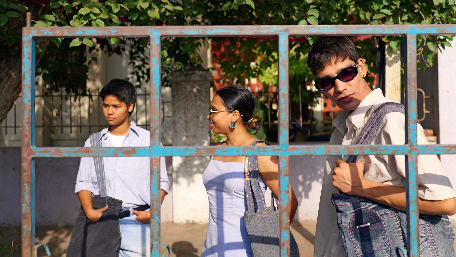 three people seen through a blue metal frame at the market